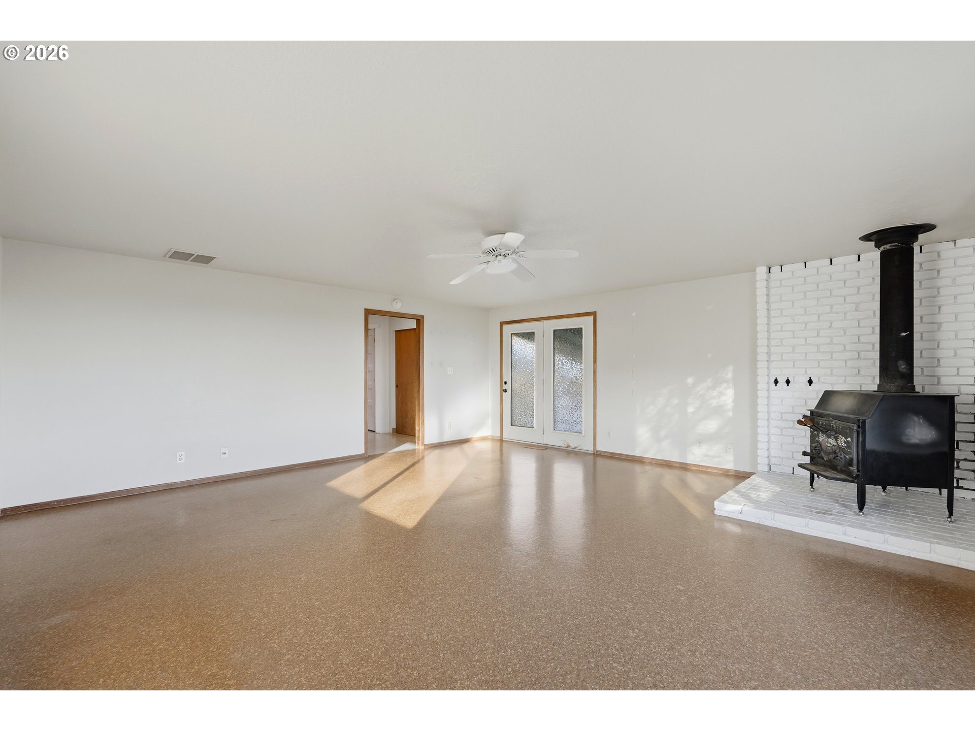 8949 South Gribble Road Canby, OR 97013 - Photo 11 of 36 a view of an empty room with wooden floor and a window
