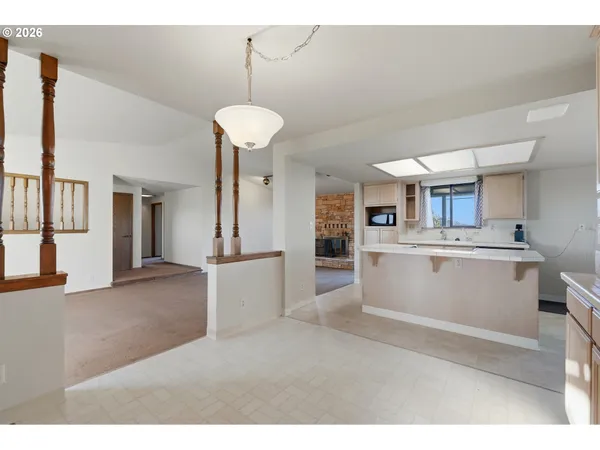 a kitchen view with white cabinets a sink dishwasher and a stove with wooden floor