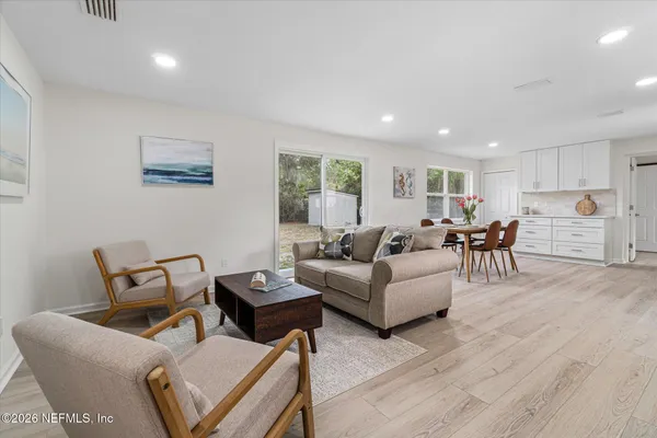 a living room with furniture and view of kitchen