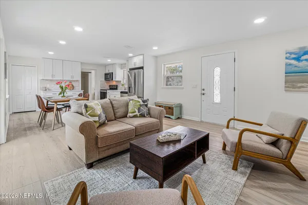 a living room with furniture a rug and a table