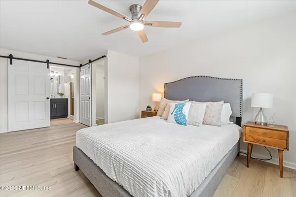 a spacious bedroom with a bed and a chandelier