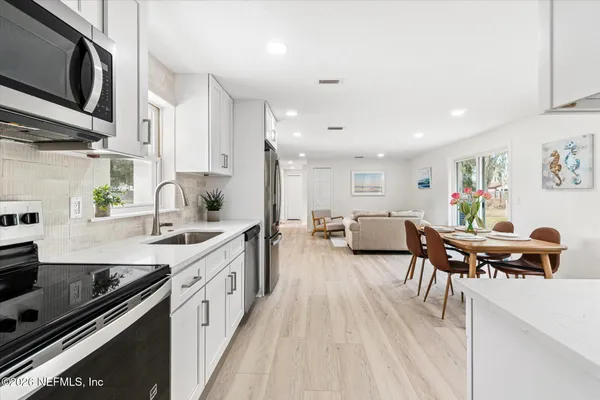 a kitchen with stainless steel appliances granite countertop a lot of counter space and wooden floors