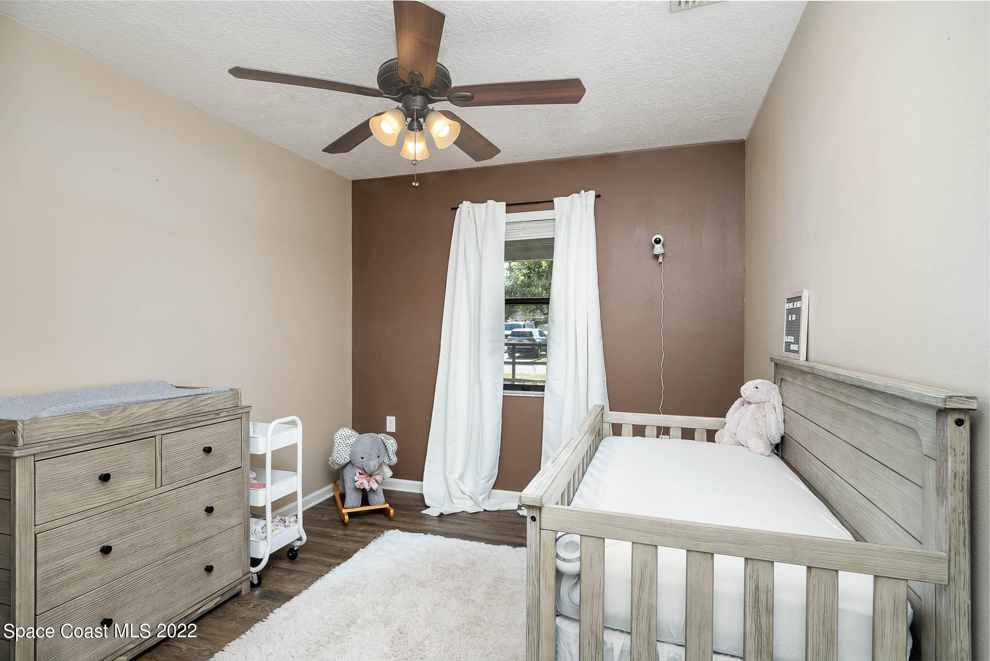 3453 Brevard Road Mims, FL 32754 - Photo 14 of 22 a bedroom with a bed and a chandelier