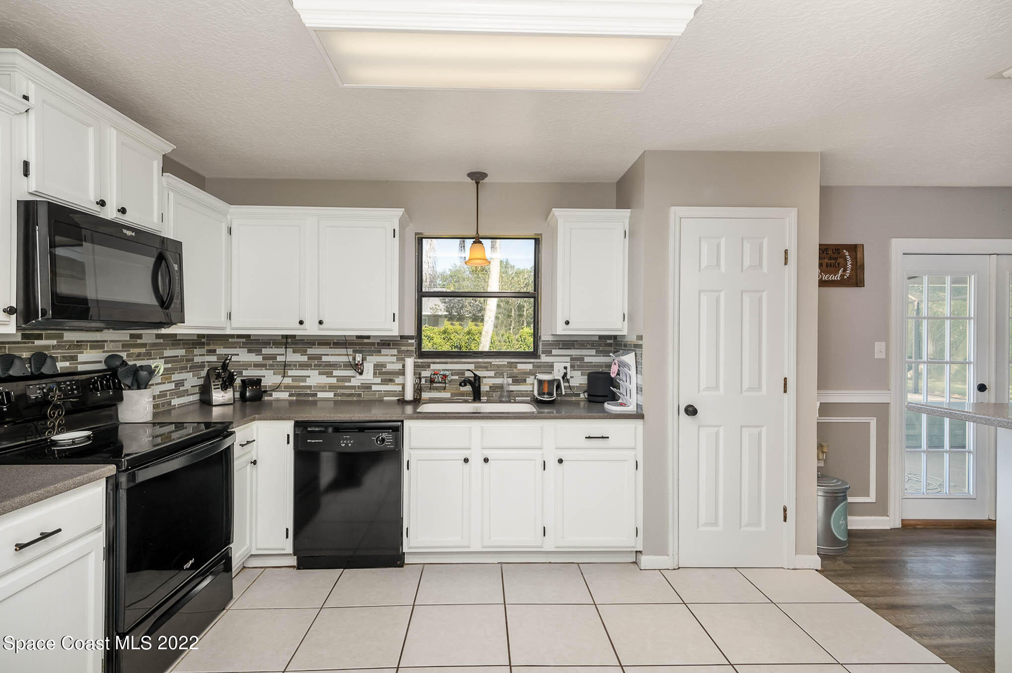 3453 Brevard Road Mims, FL 32754 - Photo 9 of 22 a kitchen with white cabinets a sink stove and refrigerator