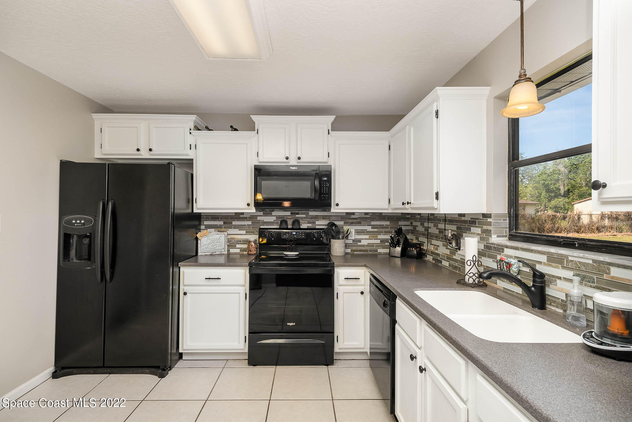 3453 Brevard Road Mims, FL 32754 - Photo 10 of 22 a kitchen with a sink a stove and refrigerator