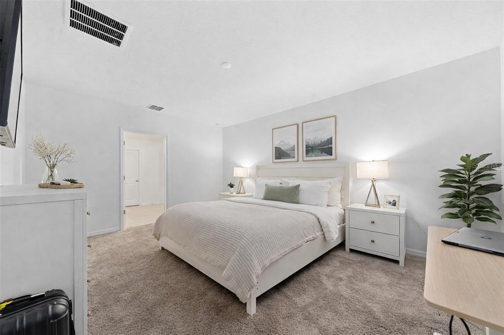3977 Willowbrook Drive Edgewater, FL 32141 - Photo 21 of 22 a bedroom with a bed and a potted plant on the dresser