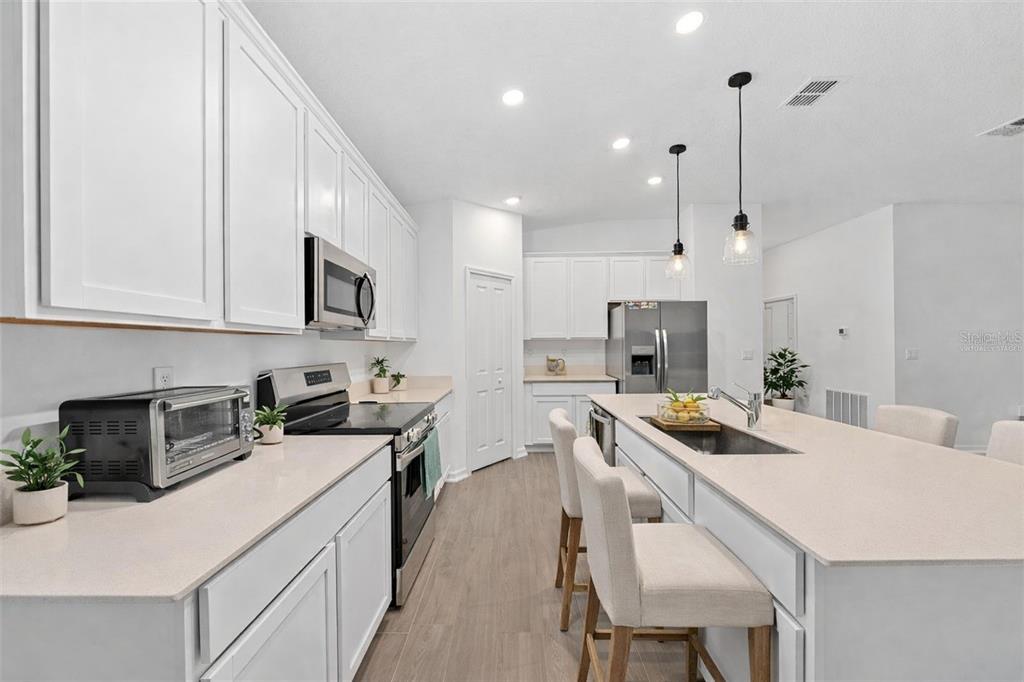 3977 Willowbrook Drive Edgewater, FL 32141 - Photo 5 of 22 a kitchen with a sink a stove a refrigerator and chairs
