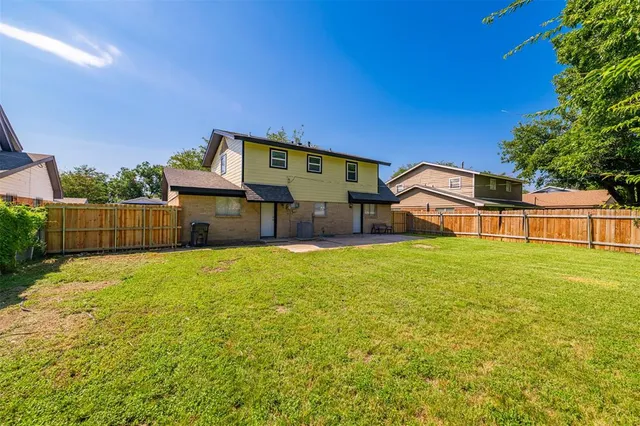 a view of a swimming pool with a yard and potted plants