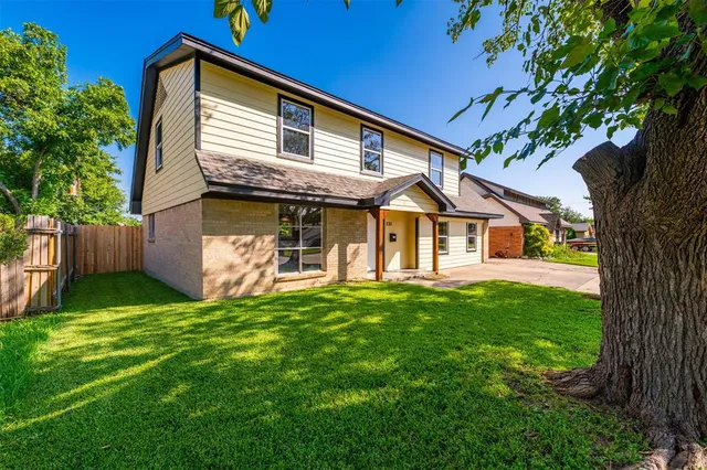 a front view of a house with a yard and potted plants