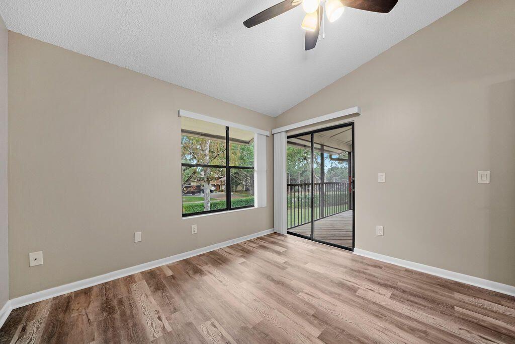12969 Pennypacker Trail, Unit 15 Wellington, FL 33414 - Photo 19 of 25 a view of an empty room with wooden floor and a window