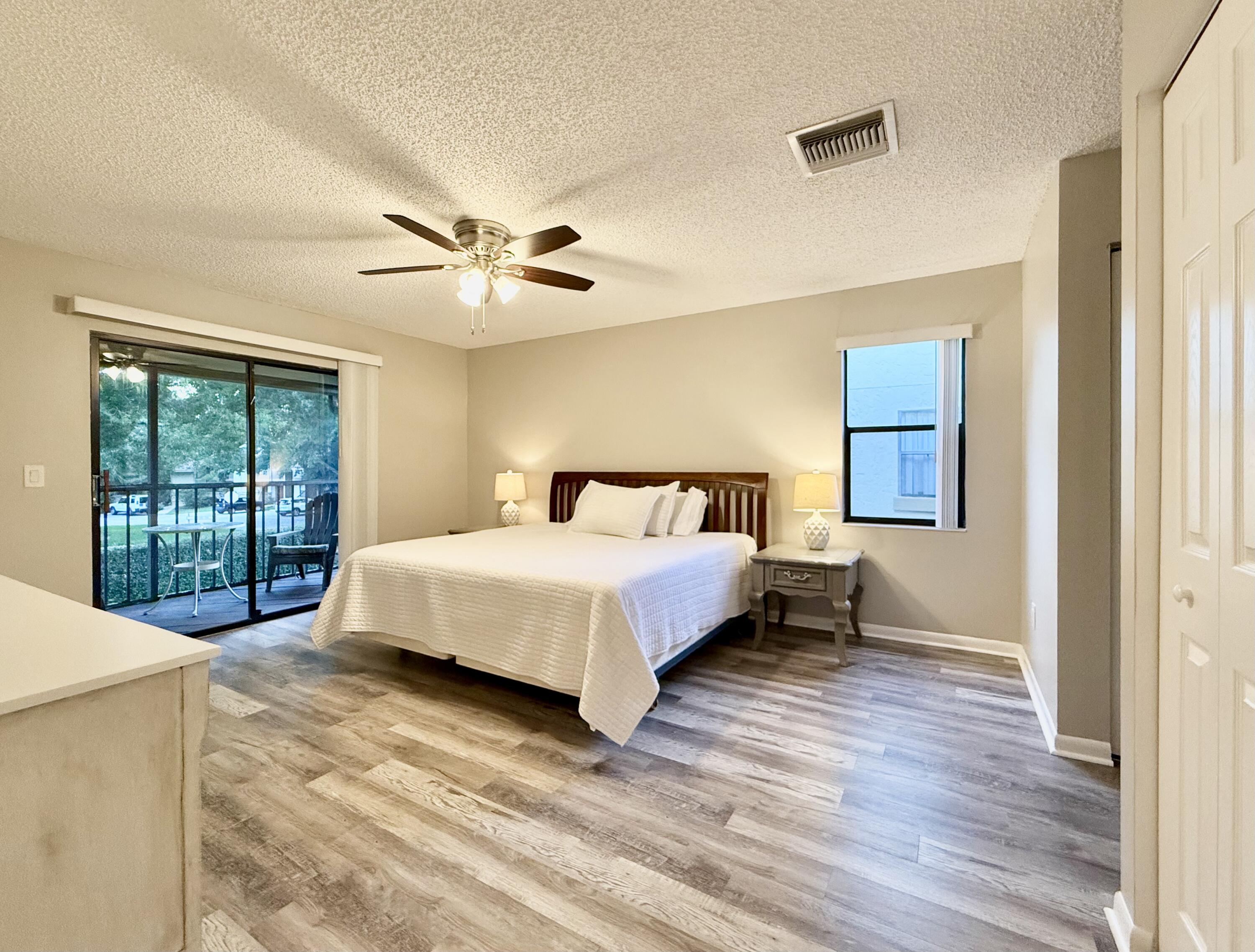 12969 Pennypacker Trail, Unit 15 Wellington, FL 33414 - Photo 5 of 25 a bedroom with a large bed and a chandelier