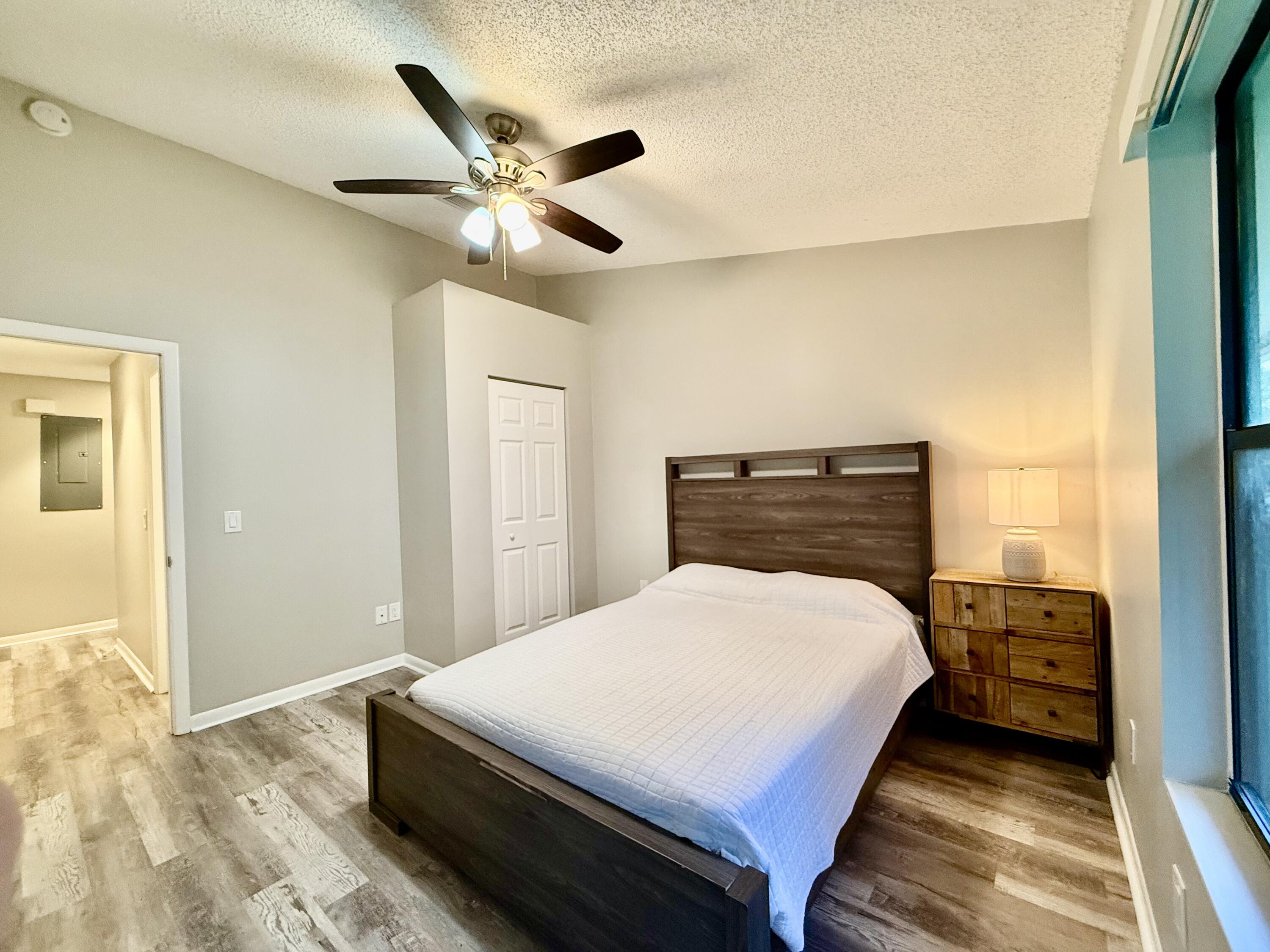 12969 Pennypacker Trail, Unit 15 Wellington, FL 33414 - Photo 9 of 25 a bedroom with a bed and a chandelier