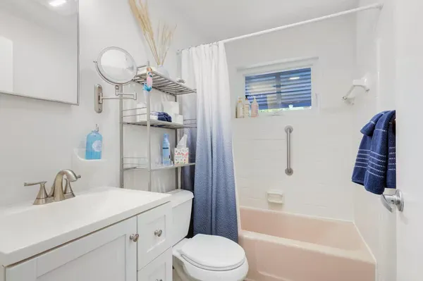 a bathroom with a sink a toilet a mirror and shower