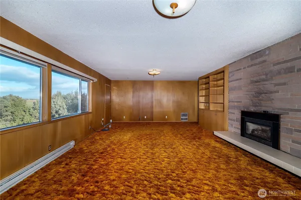 a view of an empty room with a fireplace and a window
