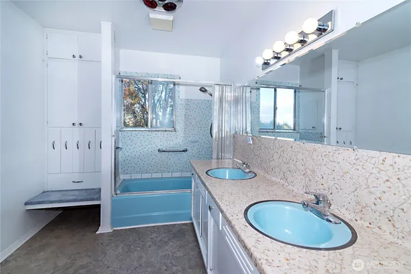 a bathroom with a granite countertop sink a mirror and shower