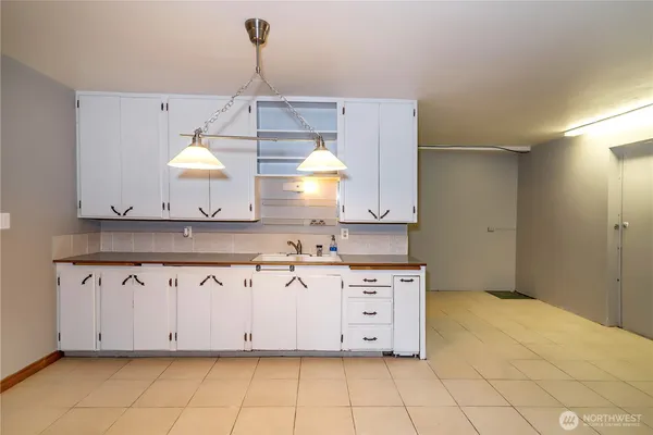 a kitchen with granite countertop a sink a stove and cabinets