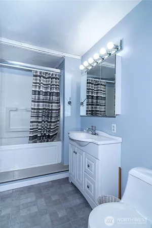 a bathroom with a double vanity sink a toilet a mirror and shower