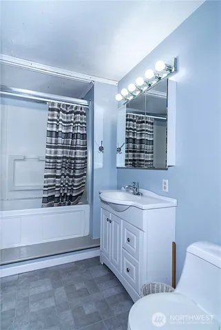 a bathroom with a double vanity sink a toilet a mirror and shower