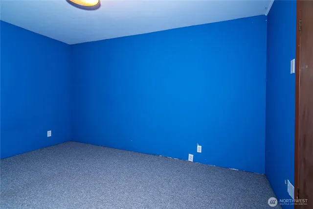 a view of an empty room with a fireplace and wooden floor