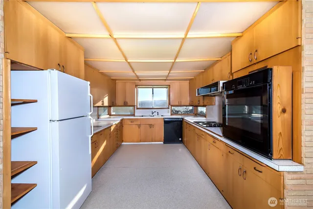 a large kitchen with stainless steel appliances granite countertop a refrigerator and a stove