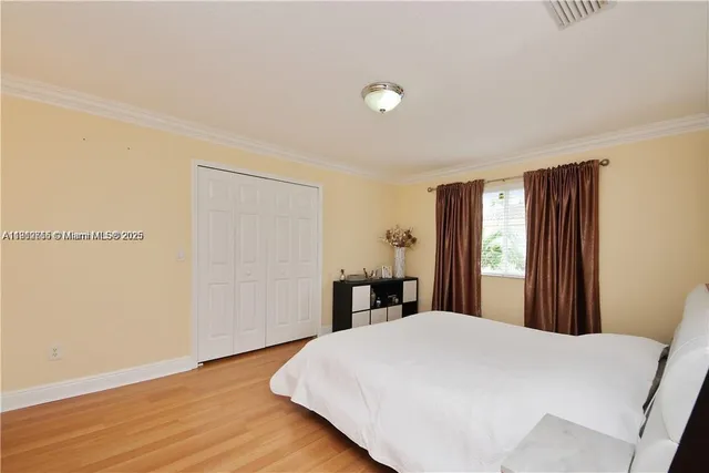 a bed sitting in a bedroom and wooden floor