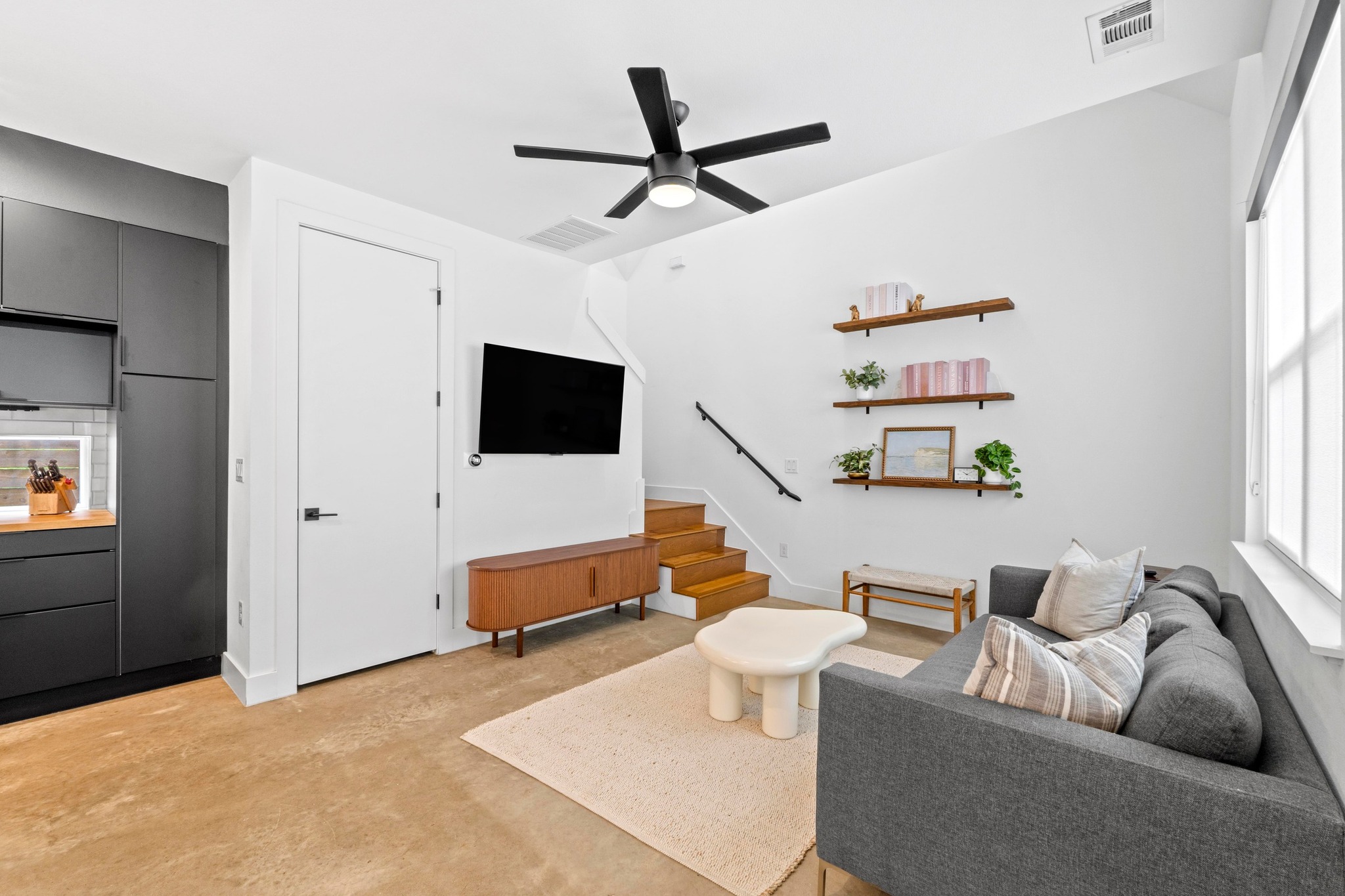 1706 Perez Street, Unit 2 Austin, TX 78721 - Photo 4 of 29 Concrete floors meet high ceilings and built-in shelving, offering a refined, contemporary living space.