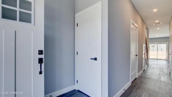 a view of a hallway with wooden floor and entryway