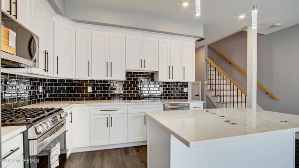 a kitchen with white cabinets appliances and a sink