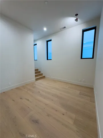 a bedroom with a bed and a flat tv screen on dresser