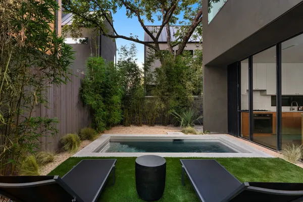 a view of a swimming pool with lawn chairs under an umbrella