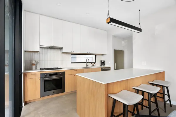 a kitchen with stainless steel appliances a stove a table and chairs