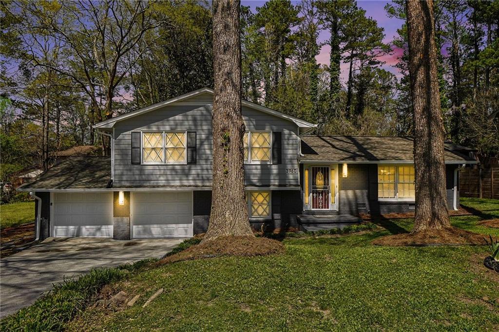 a front view of a house with a yard and trees