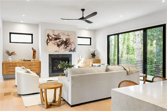 a living room with furniture a fireplace and a large window