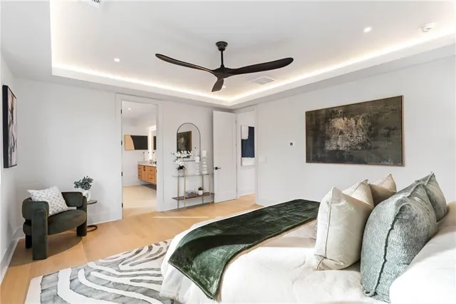 a spacious bedroom with a bed and glass walk in closet