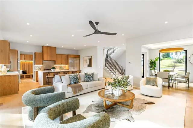 a living room with furniture kitchen view and a large window