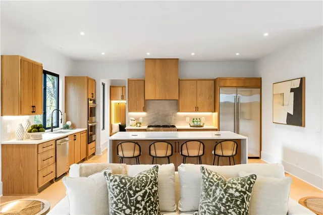 a living room with stainless steel appliances kitchen island granite countertop furniture and a large window