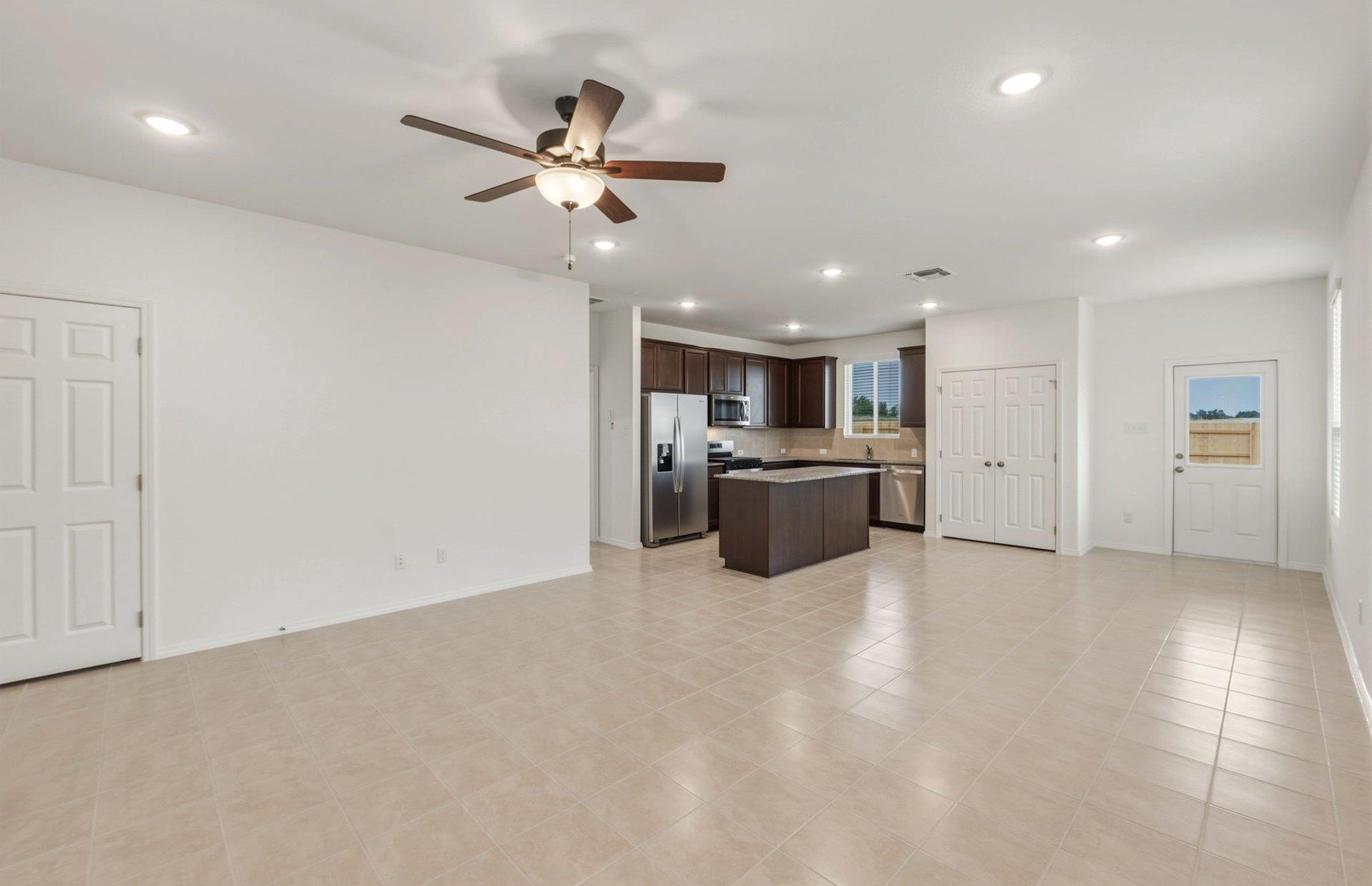 545 Henry Milton Road Georgetown, TX 78626 - Photo 10 of 33 An open layout connects the spacious living area to a modern kitchen with tile flooring.