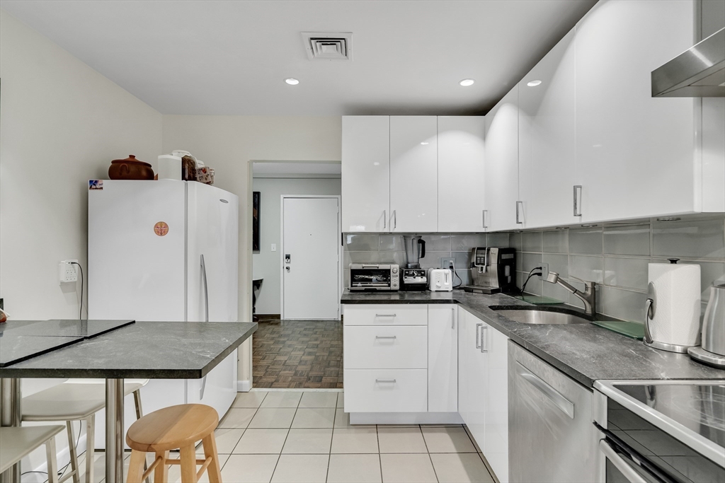 405 Langley Road, Unit 6 Newton, MA 02459 - Photo 26 of 42 a kitchen with stainless steel appliances granite countertop a sink and cabinets