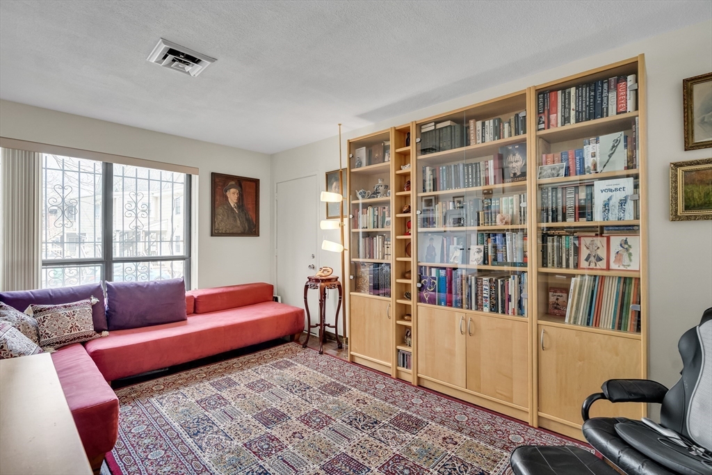 405 Langley Road, Unit 6 Newton, MA 02459 - Photo 32 of 42 a living room with furniture and book shelf