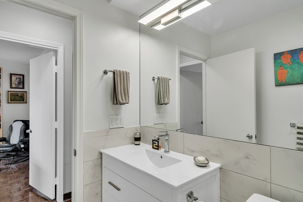405 Langley Road, Unit 6 Newton, MA 02459 - Photo 37 of 42 a bathroom with a sink a mirror and shower