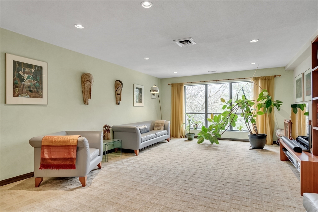 405 Langley Road, Unit 6 Newton, MA 02459 - Photo 8 of 42 a living room with furniture floor to ceiling window and a flat screen tv