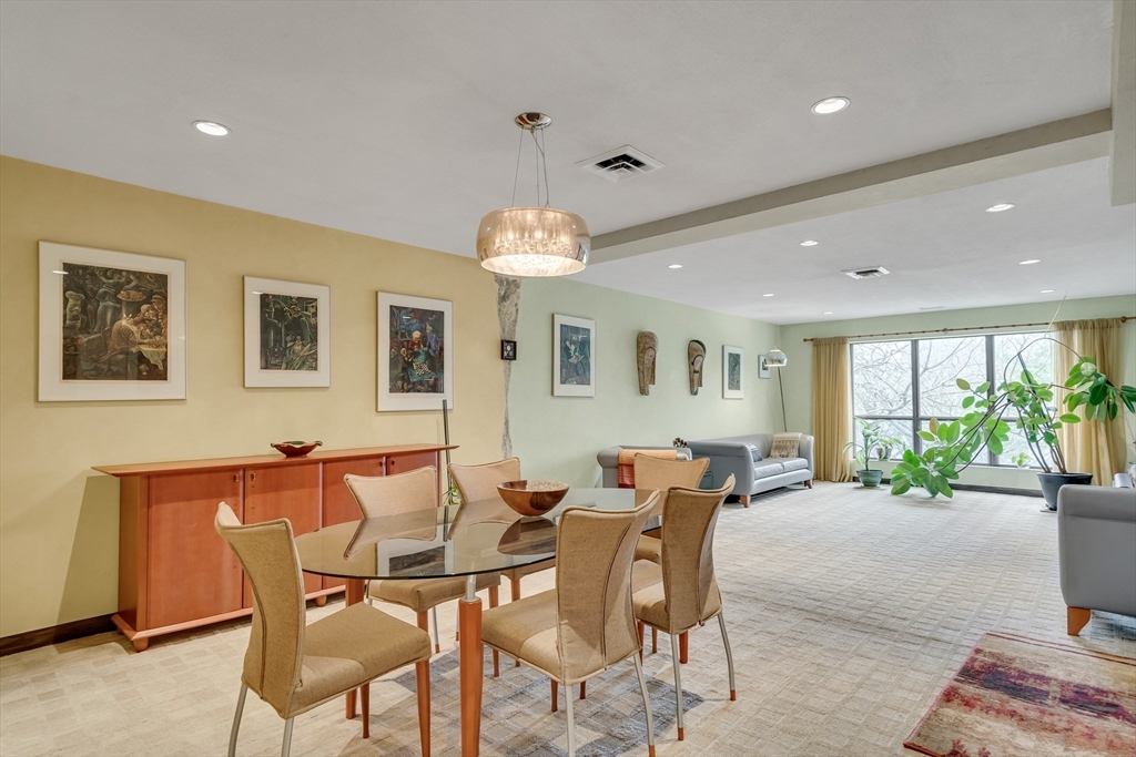 405 Langley Road, Unit 6 Newton, MA 02459 - Photo 10 of 42 a dining room with furniture a window and a chandelier