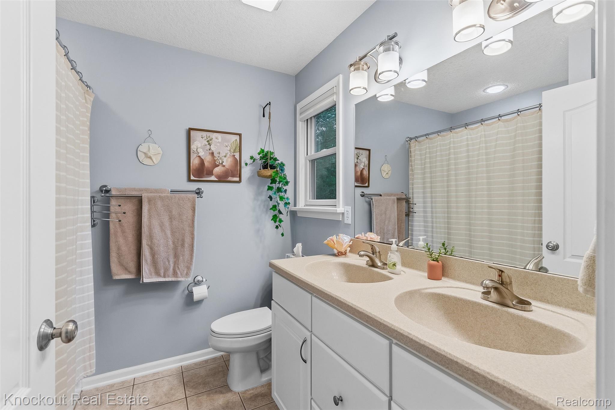 8436 Birch Run Road Millington, MI 48746 - Photo 28 of 44 Dual vanity with integrated sinks, white cabinetry, and a large wall-mounted mirror