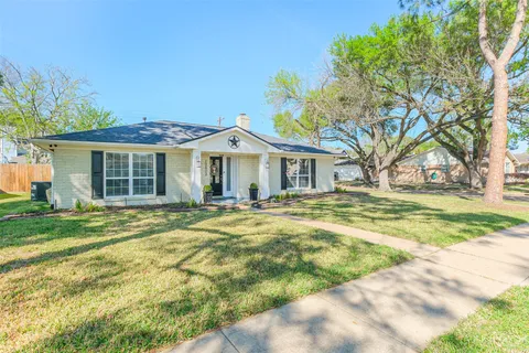 a view of a house with a backyard and a tree