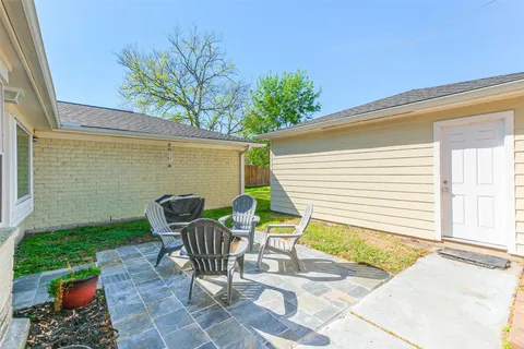 a view of a chair and table in the back yard of the house
