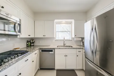 a kitchen with stainless steel appliances granite countertop a refrigerator sink and stove