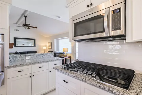 a kitchen with stainless steel appliances granite countertop a stove and a microwave