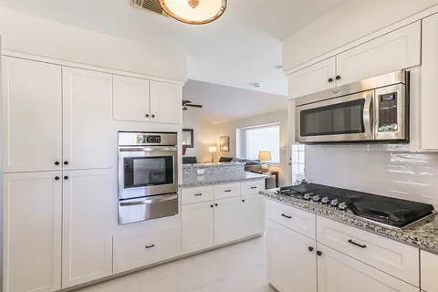 a kitchen with stainless steel appliances white cabinets and stove