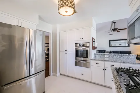 a kitchen with stainless steel appliances granite countertop a refrigerator and a stove top oven