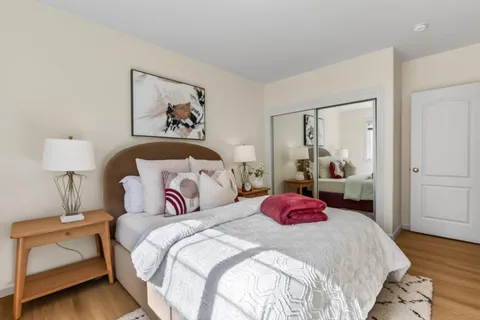 a bedroom with a bed and wooden floor